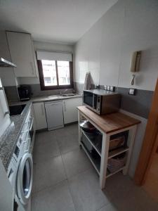 eine kleine Küche mit einer Spüle und einer Mikrowelle in der Unterkunft Nice apartment within walking distance to the center in La Cala de Mijas