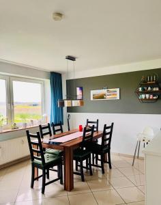 comedor con mesa de madera y sillas en Haus Vogelsand Whg 307 en Cuxhaven