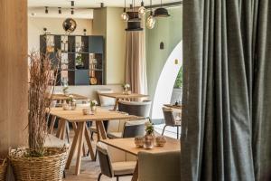 - un restaurant avec des tables, des chaises et des rideaux dans l'établissement Gloriette Guesthouse Hotel & Restaurant, à Soprabolzano