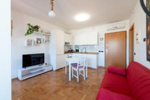 Casa Titty في روما: غرفة معيشة مع أريكة حمراء ومطبخ
