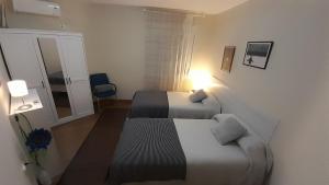 a hotel room with two beds and a window at Sevilla Nervion Santa Justa in Seville