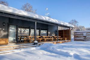 a wooden cabin with a deck in the snow at Evon Luonto Oy - Aulangon Rantala in Aulanko