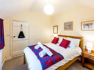 a bedroom with a large white bed with red pillows at Pass the Keys Cosy 2 bedroom Victorian Cottage in Ludlow