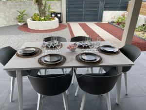 una mesa con copas de vino y platos en ella en Arbre à pain, en Bras-Panon