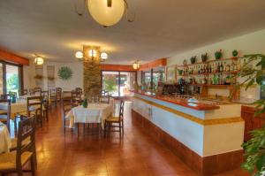 a restaurant with a bar with tables and chairs at Hotel Spartivento in Chia