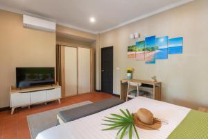 a bedroom with a bed and a flat screen tv at Sea&Sky Beach Resort in Mae Nam