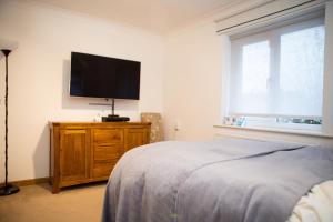 a bedroom with a bed and a flat screen tv at 2 Double bedroom House in Harrow