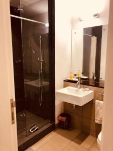 uma casa de banho com um chuveiro, um lavatório e um chuveiro em Lovely 3-bedroom at Azuri Ocean & Golf village em Roches Noires