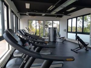 a gym with a row of treadmills and elliptical machines at Lovely 3-bedroom at Azuri Ocean & Golf village in Roches Noires