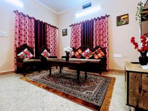 a living room with a couch and a table at Peaceful villa amidst greenery within the city. in Manipala