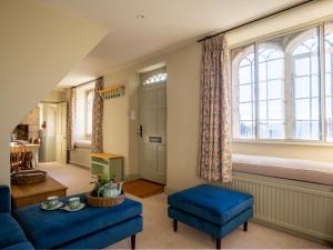 a living room with a blue couch and a window at Rose Cottage, Rodborough in Stroud