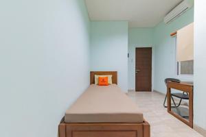 KoolKost @ The Casa 18 (minimum stay 30 nights) في باندونغ: غرفة نوم مع سرير مع وسادة برتقال عليه