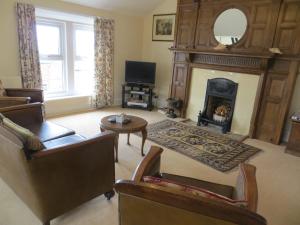 a living room with a fireplace and a tv at The Vicarage Apartment in Hunstanton