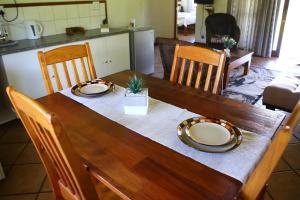 une table en bois avec deux plaques au-dessus dans l'établissement Impangele Lodge, à Muldersdrift