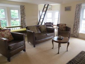 a living room with a couch and chairs and a table at The Vicarage Apartment in Hunstanton