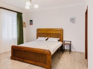 a bedroom with a wooden bed in a room at Marcos Hotel in Nizhnyaya Alekseyevka