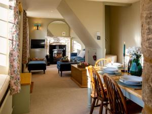 a living room with a table and a dining room at Rose Cottage, Rodborough in Stroud