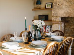een eettafel met borden en bloemen erop bij Rose Cottage, Rodborough in Stroud +17 foto's