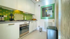 a kitchen with white cabinets and a trash can at La Sequoia - Maison dOc in Bardonecchia