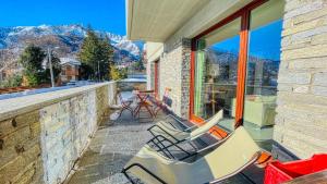 a couple of chairs sitting on a balcony with mountains at La Sequoia - Maison dOc in Bardonecchia