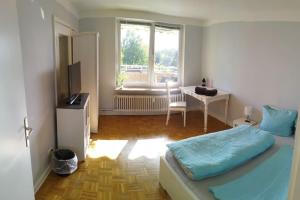 - une chambre avec un lit, un bureau et une fenêtre dans l'établissement Ferienwohnung in Kronshagen Monteurwohnung 3 Zimmer 70 m2, Küche und Badezimmer, à Kronshagen