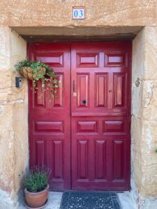 Una puerta roja con una señal. en Casa Rural Zirimiri en Herreros, Soria, en Herreros