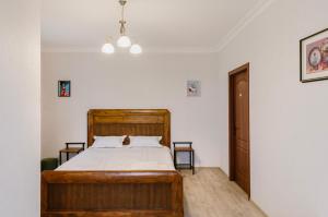 ein Schlafzimmer mit einem Holzbett in einem Zimmer in der Unterkunft Marcos Hotel in Nizhnyaya Alekseyevka