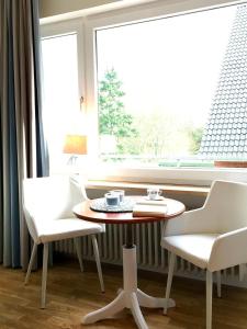 グレーミッツにあるHaus am Kurpark - Strandhaferの窓際のテーブルと椅子2脚