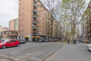 una calle en una ciudad con coches y edificios en I Host Apartment - Giambellino 40, en Milán