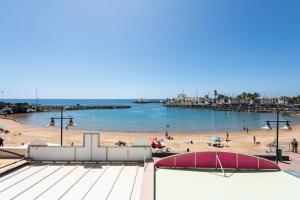 a view of a beach with people on the sand at Mogan Beach Blue Sky in Mogán