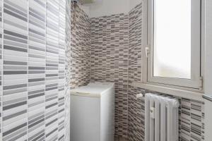 baño pequeño con aseo y ventana en I Host Apartment - Giambellino 40, en Milán