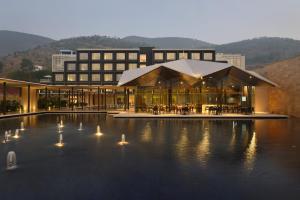 a building with lights in the water in front of it at Marasa Sarovar Premiere in Tirupati