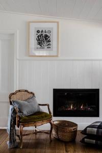 - un salon avec une chaise et une cheminée dans l'établissement Port Cottage on the Great Ocean Road, à Port Campbell