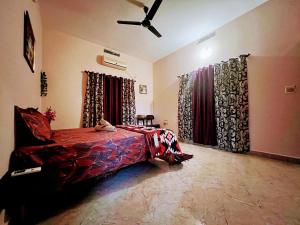 a bedroom with a bed and a ceiling fan at Peaceful villa amidst greenery within the city. in Manipal