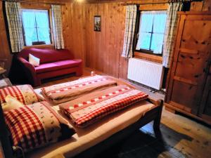 a room with two beds and a chair and windows at Waschhütte, Ferienhaus in Finkenberg