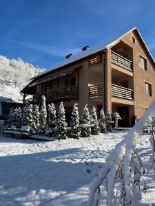 a building in the snow with snow covered trees at Купецький Двір in Mizhhirya