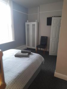 a bedroom with a bed and a chair and a window at Liverpool city 5 bed house sleeps 12 in Liverpool