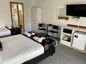 Habitación de hotel con 2 camas y TV de pantalla plana. en Motel Stawell en Stawell