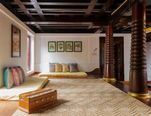 a room with two beds and a suitcase on the floor at SaffronStays Amaya, Kannur - 300 years old heritage estate for families and large groups in Kannur