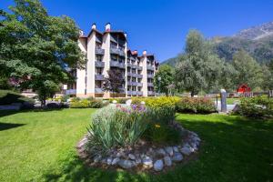 un bâtiment d'hôtel avec un jardin dans la cour dans l'établissement Résidence Grand Roc - Bruyères 207 - Happy Rentals, à Chamonix-Mont-Blanc