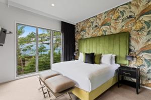a bedroom with a large bed and a large window at Club Wyndham Airlie Beach in Airlie Beach