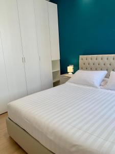 um quarto com uma grande cama branca e uma parede azul em Fifty Eight Milan Beltrade 3 em Milão