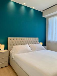 um quarto com uma cama grande e uma parede azul em Fifty Eight Milan Beltrade 3 em Milão