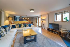 a living room with a couch and a tv at Pondside Barn in Long Wittenham