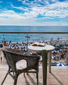 stół i krzesło na balkonie z plażą w obiekcie Hotel Maremola w mieście Pietra Ligure