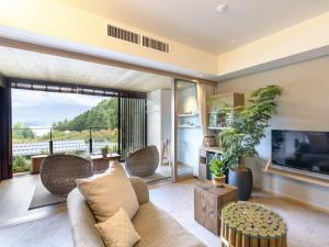 a living room with a couch and a tv at Fufu Kawaguchiko in Fujikawaguchiko