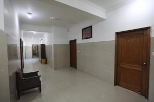 a hallway with a chair and a wooden door at Hotel Neelkanth Katra Managed By Mahadev Hotel and Resorts in Katra