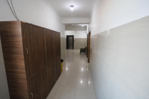 un corridoio con porte in legno e un corridoio con una sedia di Hotel Neelkanth Katra Managed By Mahadev Hotel and Resorts a Katra