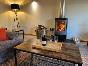 una sala de estar con una botella de vino y copas en una mesa en Charming Countryside Cottage, en Ivybridge