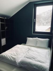 łóżko w niebieskim pokoju z oknem w obiekcie Dom pod lasem w Bielsku Białej